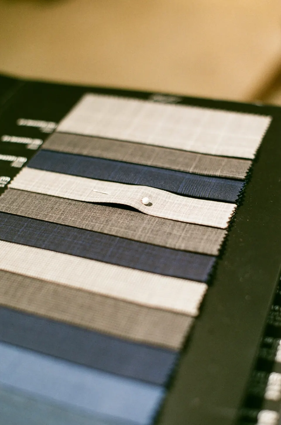 Swatch card of grey and navy suiting fabrics